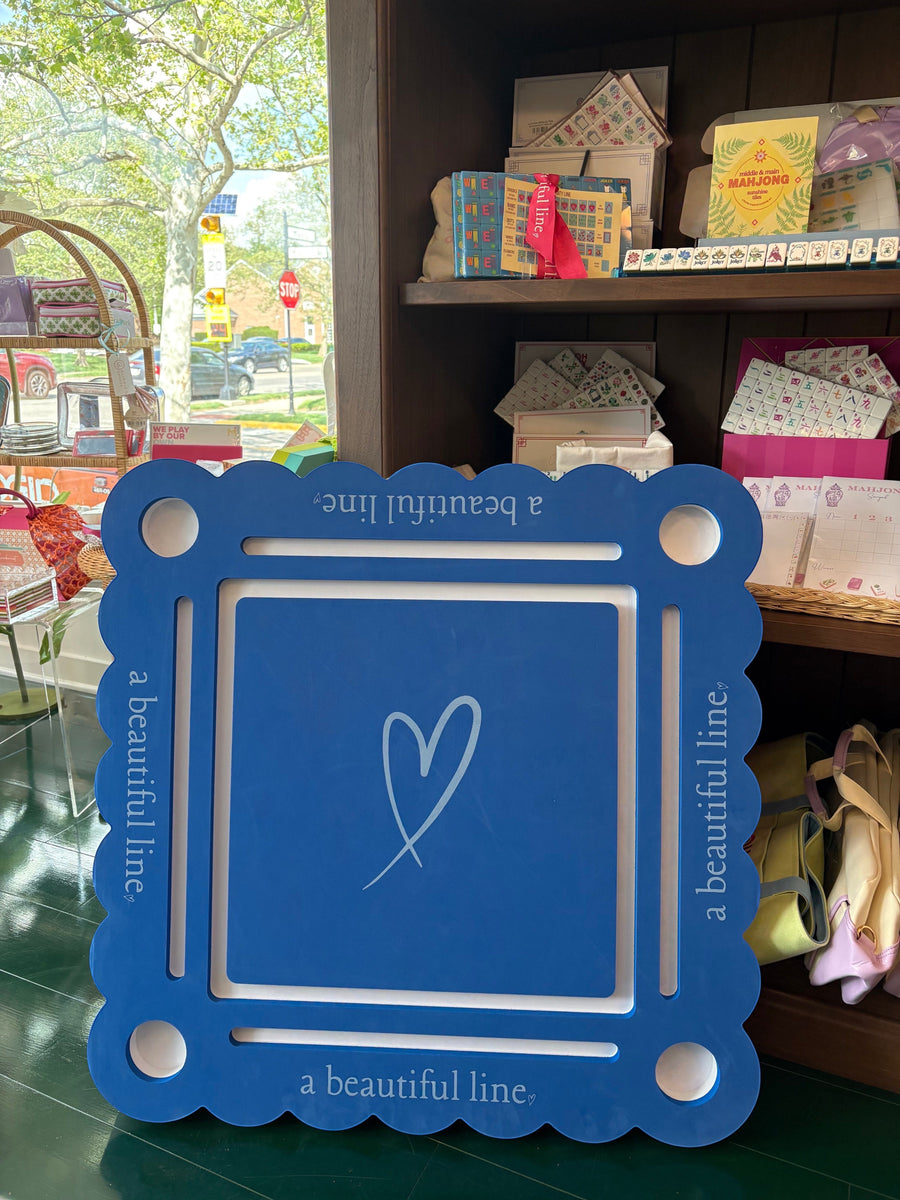 Bobbie's Shoppe blue and white mahjong pool mat with scalloped edges and a heart graphic. Holds drinks and tiles.