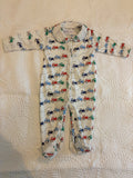 Bobbie's Shoppe white footed pajamas with all-over print of red, blue, and green tractors. Features a collar and zipper closure.